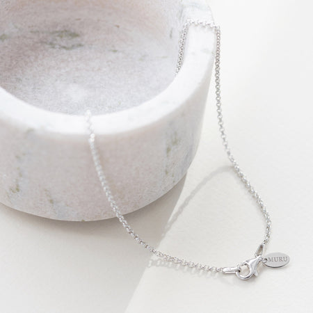 the clasp and tag of a silver belcher chain. Tag is engraved with 'Muru'